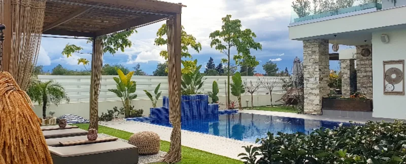 Luxury villa garden with pool, pergola and refined Mediterranean planting in Cyprus